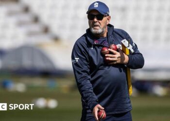 Darren Lehmann prepares to catch a cricket ball while wearing a baseball mitt
