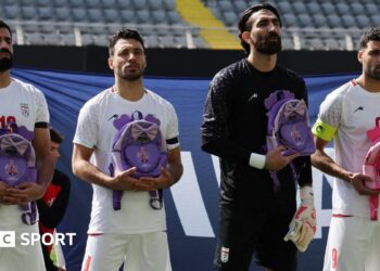 Iran's Hossein Kanaani, Shoja Khalilzadeh, Alireza Beiranvand and Mehdi Taremi hold school bags in memory of the victims of the girls school bombing in Minab, Iran