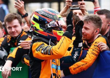Oscar Piastri gives high fives to his McLaren team members after coming second at Suzuka