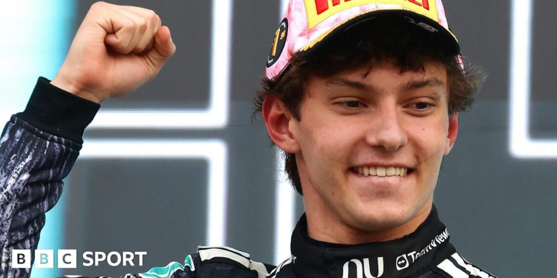 Kimi Antonelli smiles and clenches his fist in celebration on the podium after winning the Japanese Grand Prix