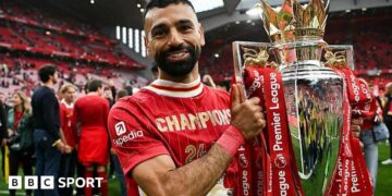 Mohamed Salah poses with the Premier League trophy