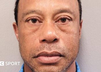Tiger Woods in a red shirt and white cap