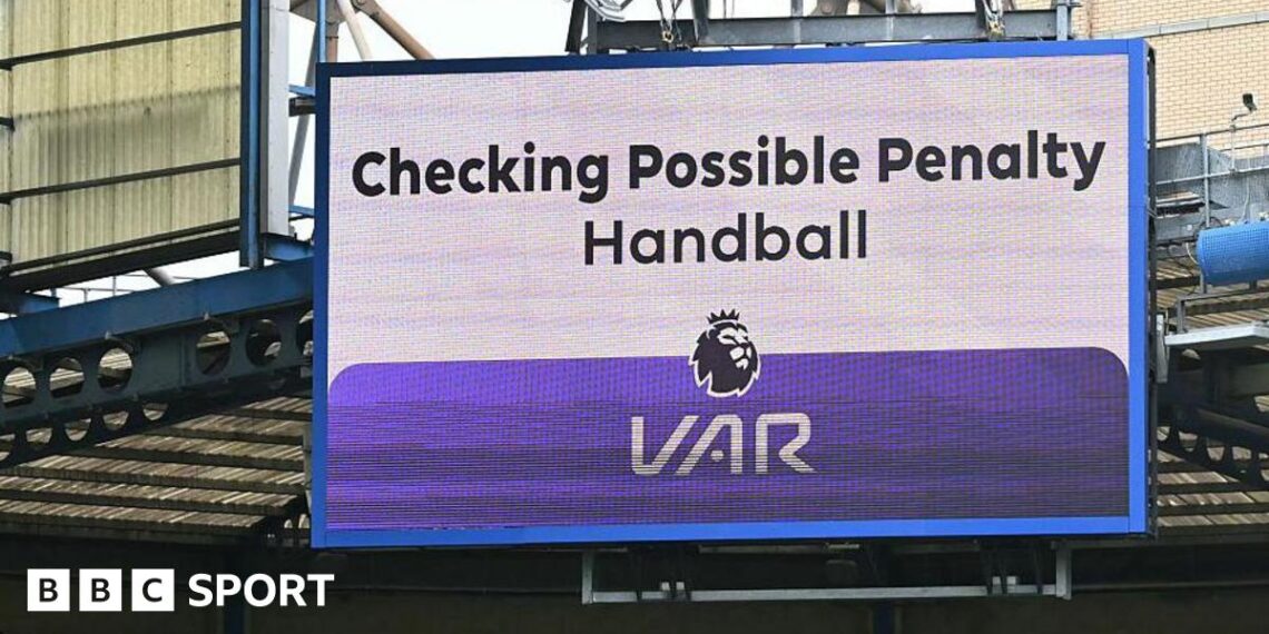 A big screen display a VAR check for a possible penalty during a Premier League match