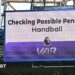 A big screen display a VAR check for a possible penalty during a Premier League match