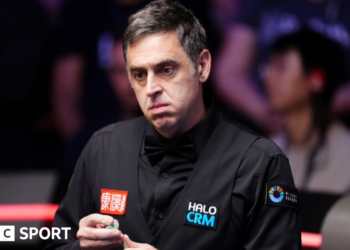 Ronnie O'Sullivan chalking his cue