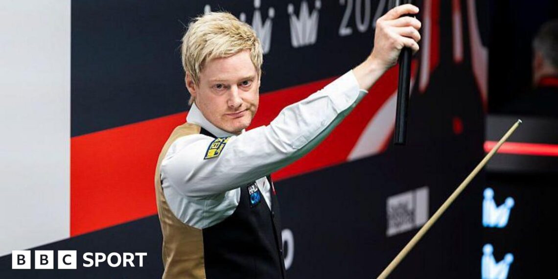 Neil Robertson holds his cue extension aloft