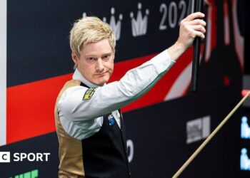 Neil Robertson holds his cue extension aloft