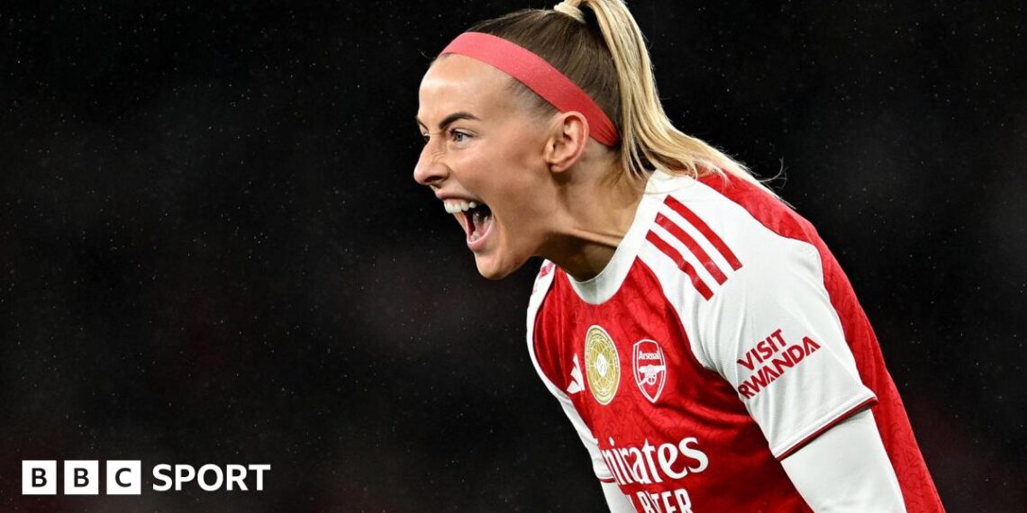 Chloe Kelly slides on her knees in celebration while wearing Arsenal's red and white kit and a red headband