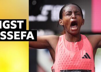 Tigst Assefa celebrates London Marathon win with eyes closed, mouth open and arms outstretched