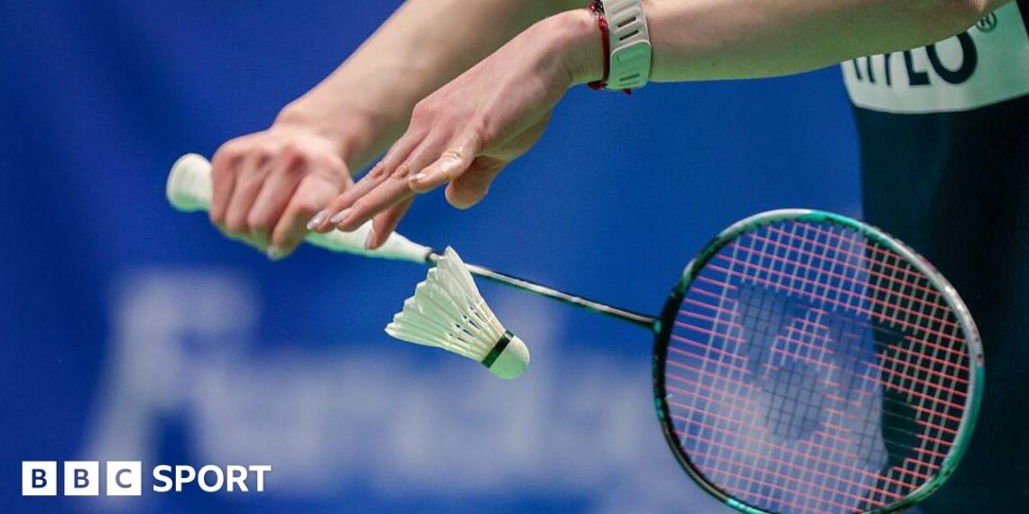 Badminton player serves a shuttlecock