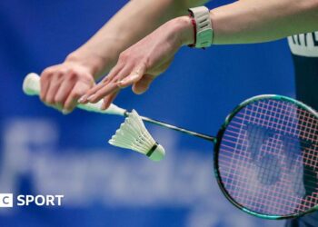 Badminton player serves a shuttlecock