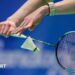 Badminton player serves a shuttlecock