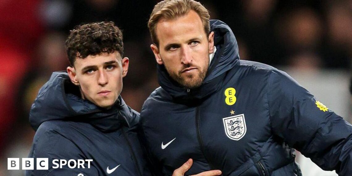 Phil Foden and Harry Kane in England blue coats after the defeat by Japan, with both players stern-faced