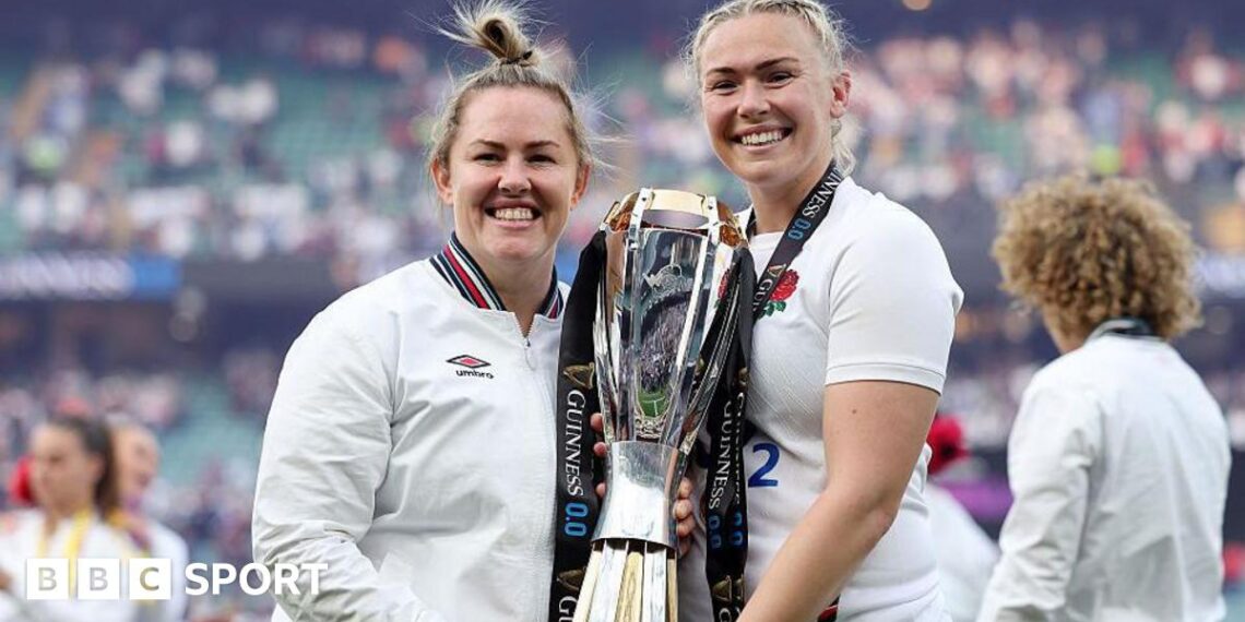 Marlie Packer and Rosie Galligan pose for a photograph holding the RWC trophy