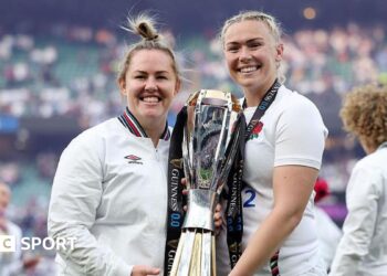 Marlie Packer and Rosie Galligan pose for a photograph holding the RWC trophy