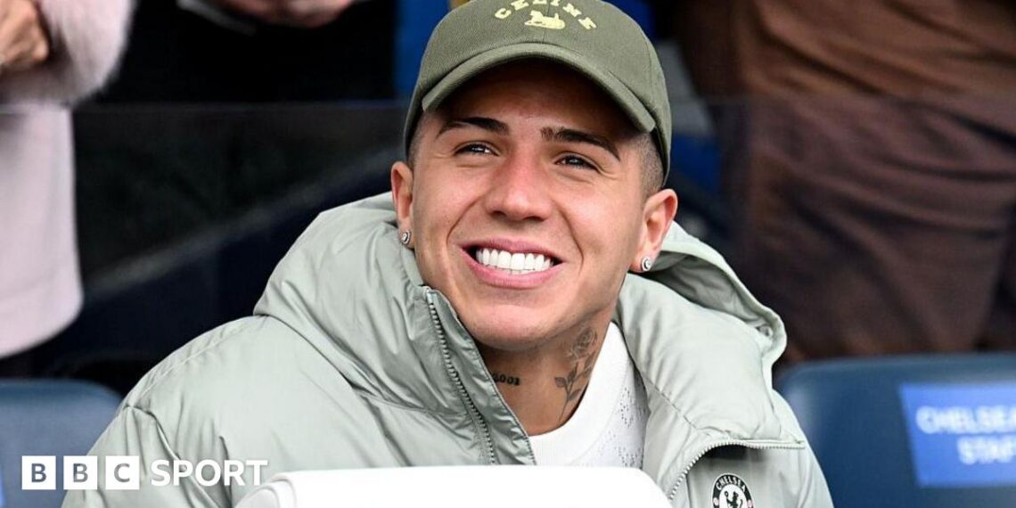 Enzo Fernandez smiling while in sat down in a Chelsea jacket