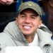 Enzo Fernandez smiling while in sat down in a Chelsea jacket