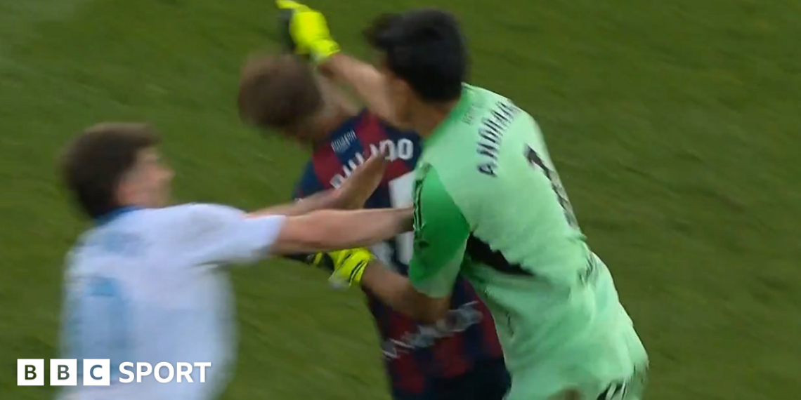Real Zaragoza goalkeeper Esteban Andrada punches Huesca captain Jorge Pulido
