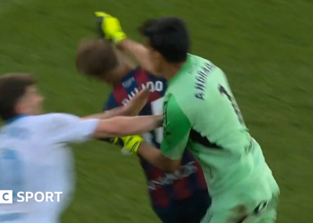 Real Zaragoza goalkeeper Esteban Andrada punches Huesca captain Jorge Pulido