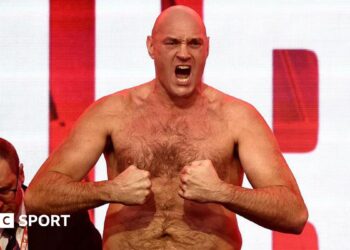 Tyson Fury tenses for the cameras at the weigh-in