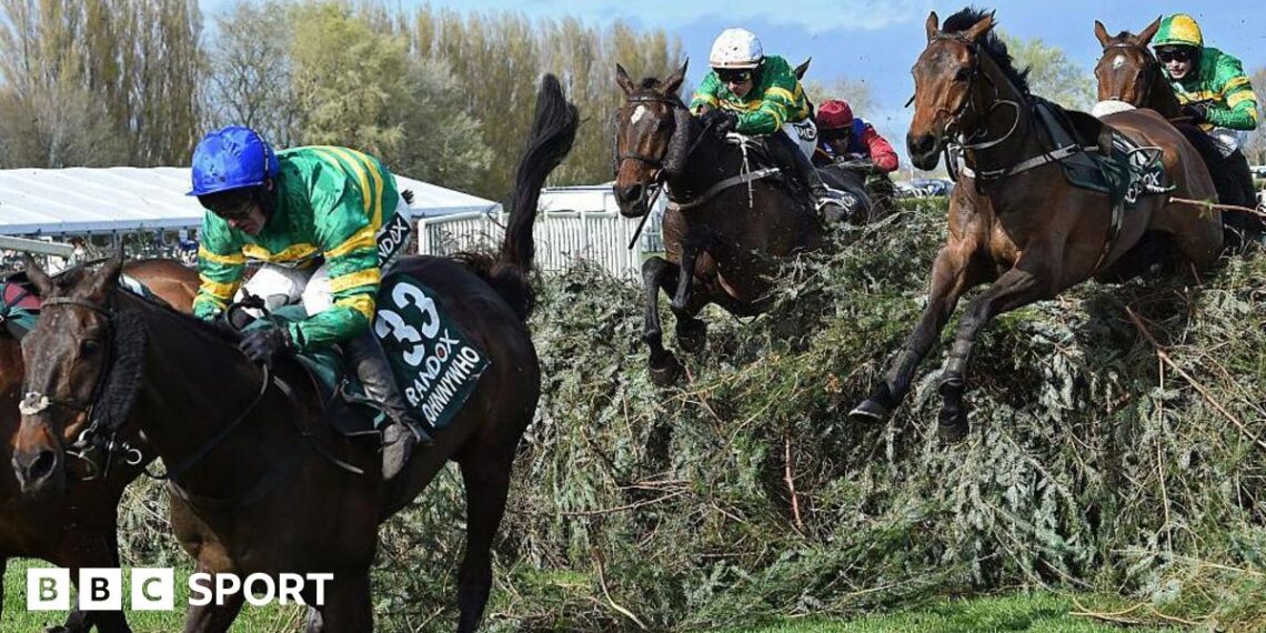 Horses jump one of the Grand National fences in the 2026 race
