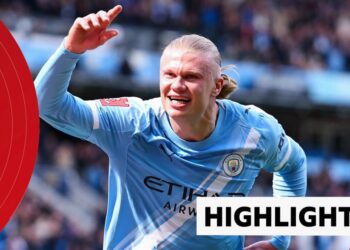 Erling Haaland of Manchester City smiles and celebrates his goal with one arm in the air