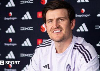 Harry Maguire smiling in a Manchester United news conference
