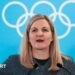 IOC president Kirsty Coventry speaking at the Winter Olympics against a background of the Olympic rings.