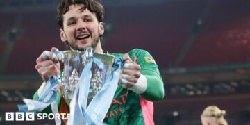 James Trafford holds the Carabao Cup trophy