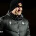 Departed Catalans Dragons head coach Joel Tomkins in club emblazoned hat and coat