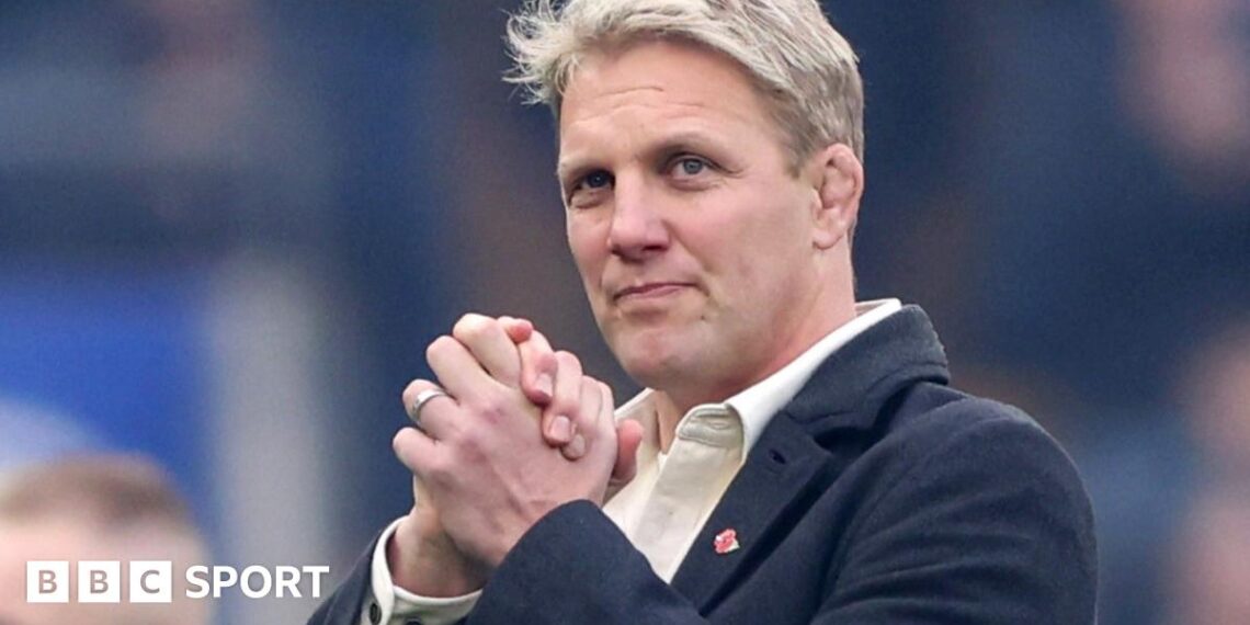 Lewis Moody smiles while clasping his hands