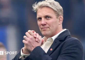 Lewis Moody smiles while clasping his hands