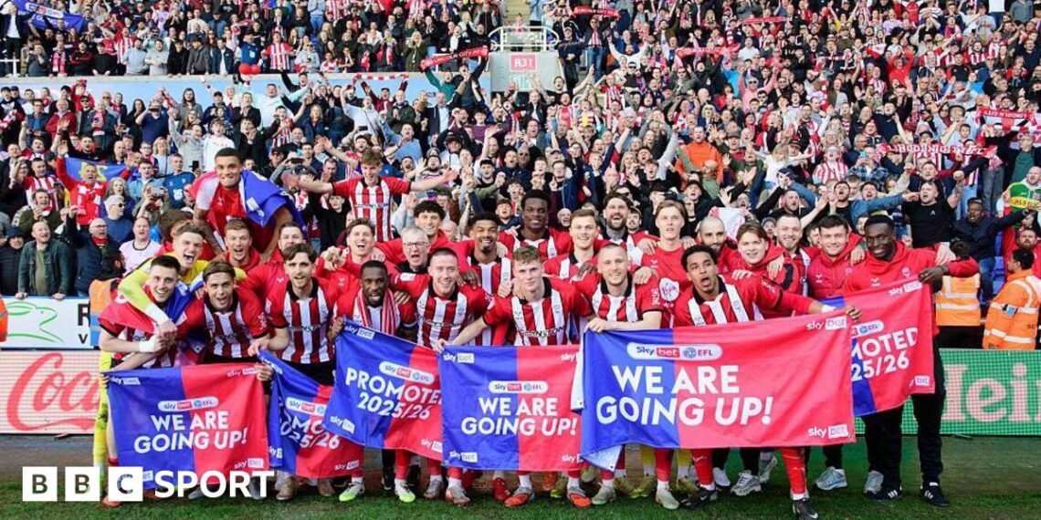 The Lincoln City squad celebrating their promotion infront of their visiting supporters at Reading's Select Car Leasing Stadium.
