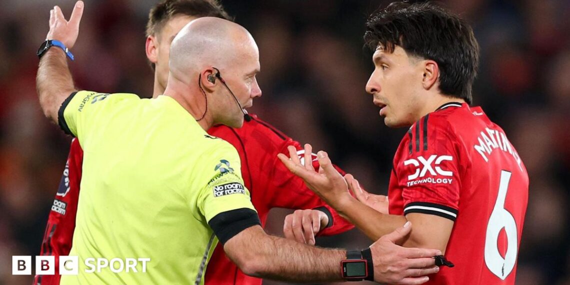 Referee Paul Tierney speaks with Lisandro Martinez of Manchester United after showing him a red card for pulling the hair of Dominic Calvert-Lewin of Leeds United