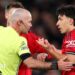 Referee Paul Tierney speaks with Lisandro Martinez of Manchester United after showing him a red card for pulling the hair of Dominic Calvert-Lewin of Leeds United