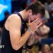 LA Lakers star Luka Doncic covers his face with his hands as he walks off the court after suffering an injury