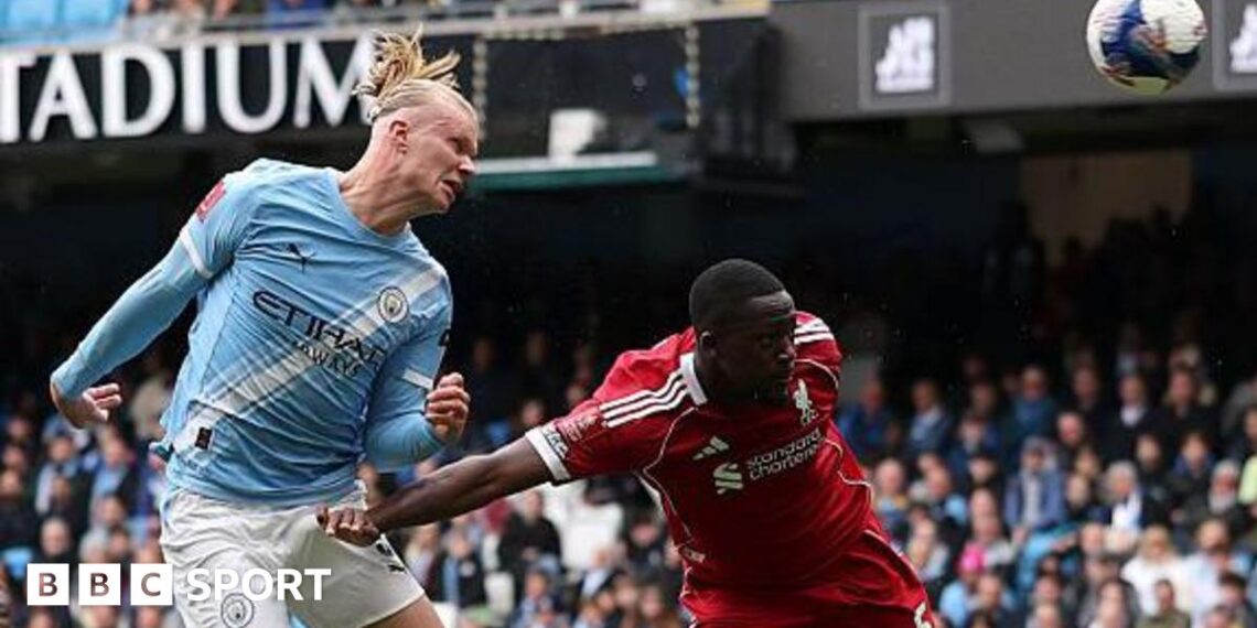 Erling Haaland, wearing Manchester City's light blue kit, celebrates his latest hat-trick by making a three-finger salute with his left hand
