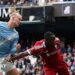 Erling Haaland, wearing Manchester City's light blue kit, celebrates his latest hat-trick by making a three-finger salute with his left hand