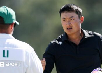 Li Haotong fist bumps his caddie at the 2026 Masters