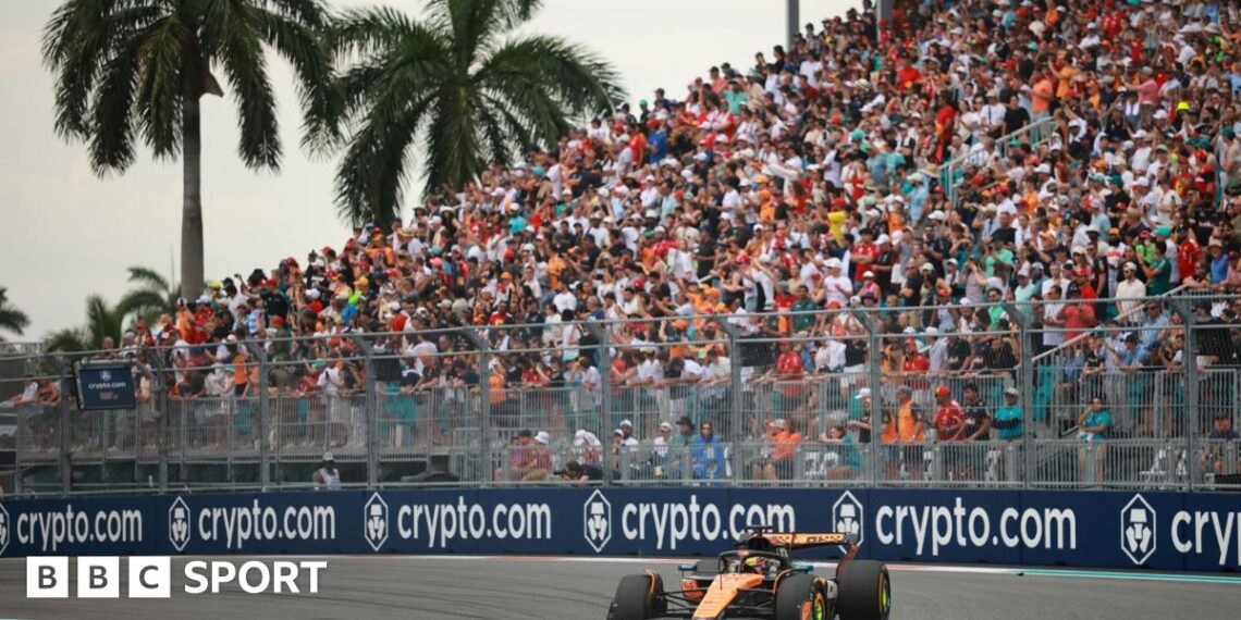 McLaren's Oscar Piastri turns into a right-hand corner during the 2025 Miami Grand Prix. A packed grandstand and two palm trees are in the background