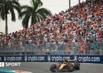 McLaren's Oscar Piastri turns into a right-hand corner during the 2025 Miami Grand Prix. A packed grandstand and two palm trees are in the background