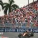McLaren's Oscar Piastri turns into a right-hand corner during the 2025 Miami Grand Prix. A packed grandstand and two palm trees are in the background