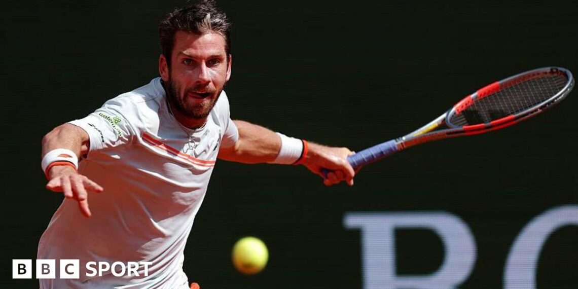 Cameron Norrie, in largely white T-shirt with orange trim, plays a forehand at the Monte Carlo Masters on Sunday