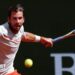 Cameron Norrie, in largely white T-shirt with orange trim, plays a forehand at the Monte Carlo Masters on Sunday