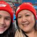 Sophie Fawns with her mother, Maureen, both smiling and wearing NSW Swifts red woolly hats