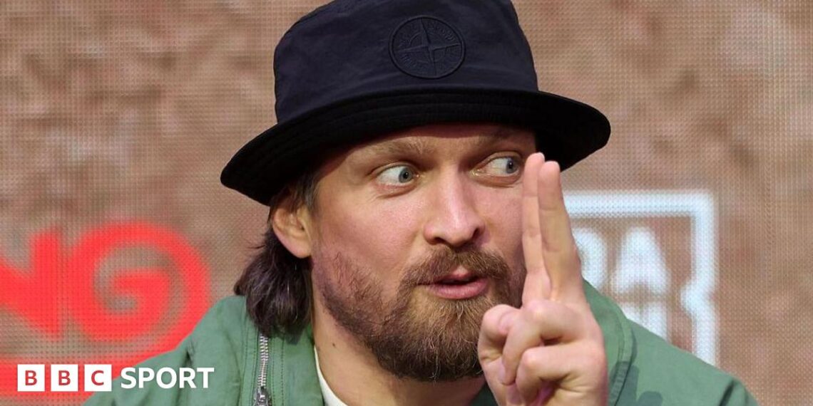 Oleksandr Usyk holds up his finger while speaking