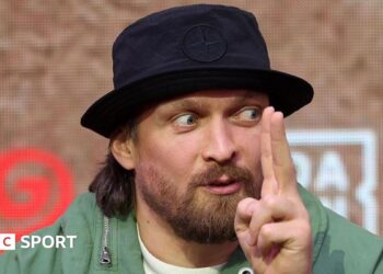 Oleksandr Usyk holds up his finger while speaking
