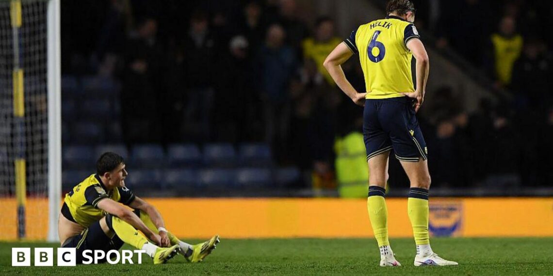 Oxford players Will Lankshear and Michal Helik look disconsolate following their defeat by Wrexham