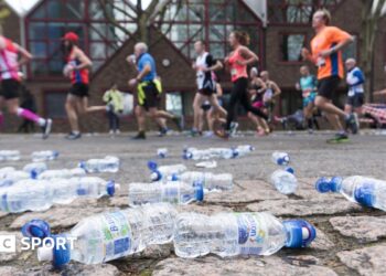 Discarded plastic bottles on the side of a marathon course