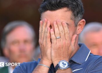 Rory McIlroy covers his face with his hands